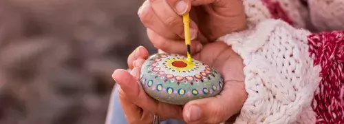 a person painting a rock